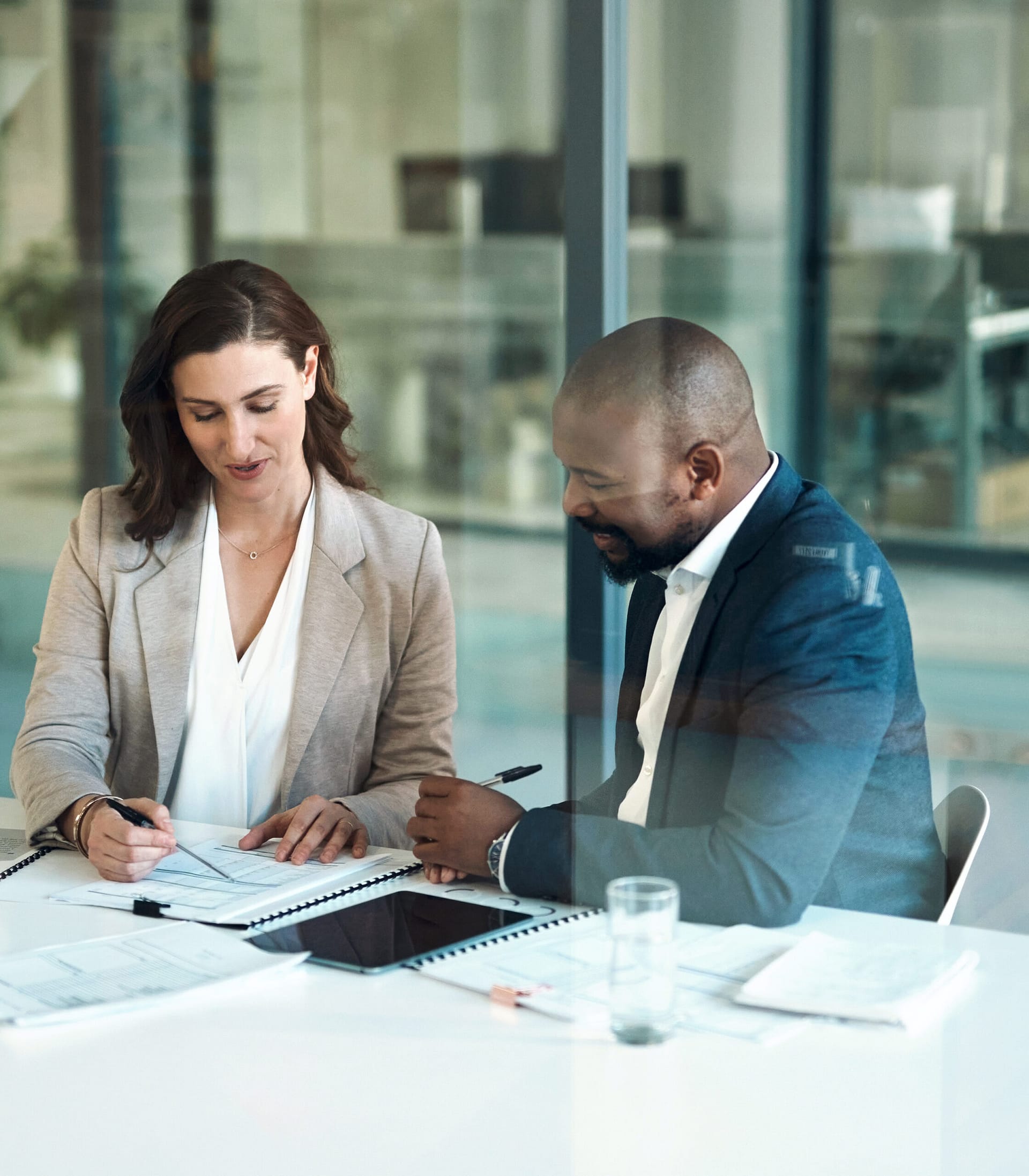 Office, meeting and documents of business people, clients or team for taxes, audit or revenue report in accounting. Paperwork, review and advice of woman, financial advisor or accountant support