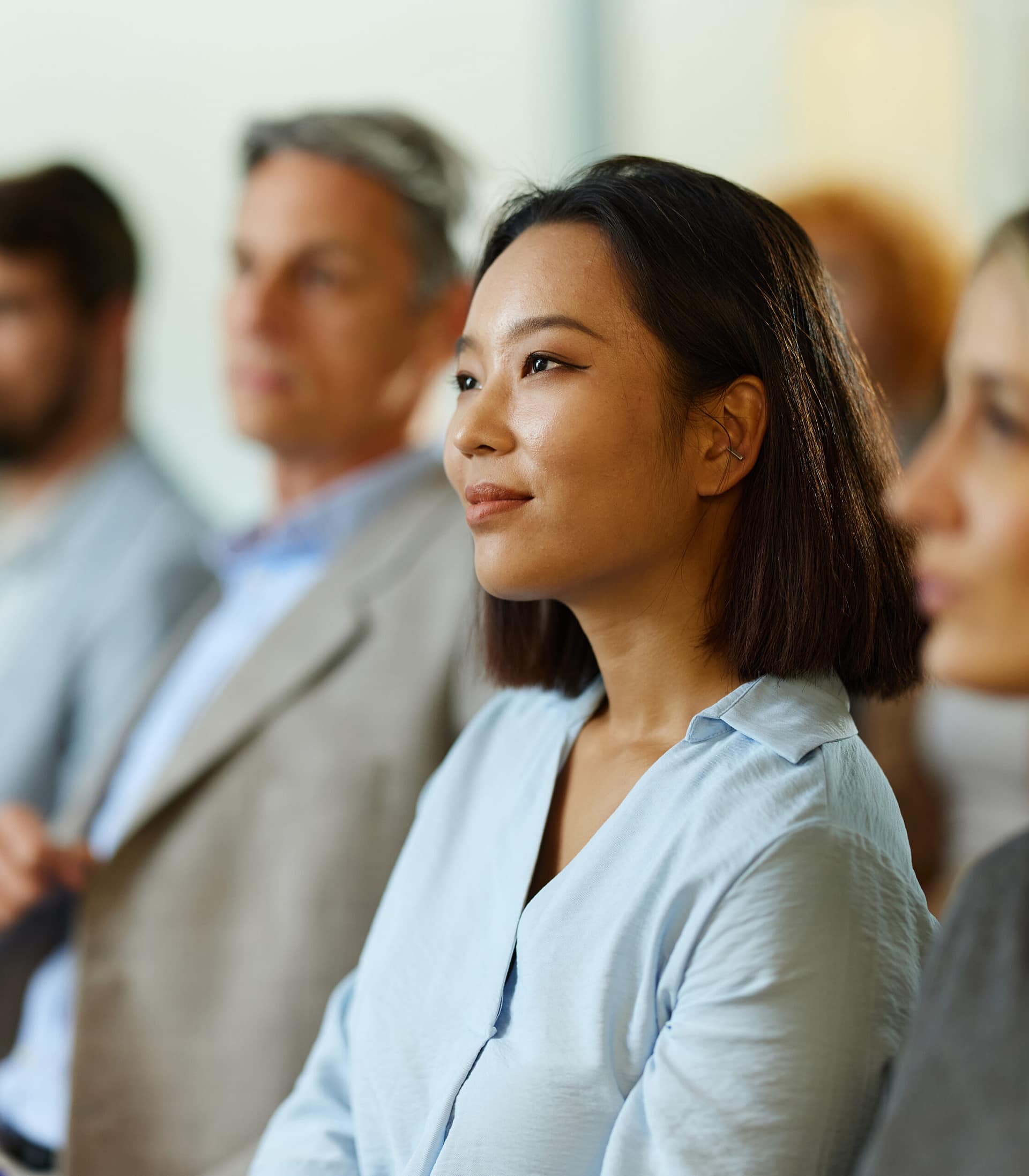 Smiling businesswoman attending a seminar with her colleagues.